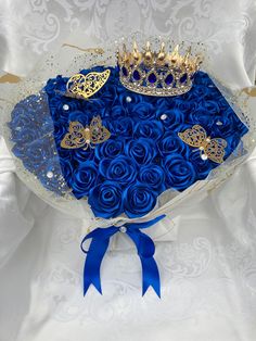 a bouquet of blue roses with a crown on top