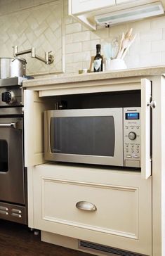 a microwave oven sitting on top of a cabinet in a kitchen next to an oven