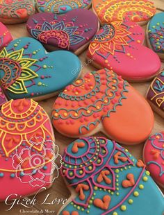 decorated cookies are arranged on a table for display in the shape of hearts and flowers