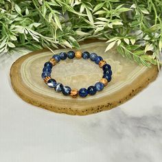 Experience the essence of harmony with the artisan-made Sodalite and Palm Wood Unisex Bracelet. This captivating accessory unites the tranquil allure of Sodalite and the rustic charm of Palm Wood, creating a wearable masterpiece that resonates with both elegance and earthy energy. Centered around the serene Sodalite beads, the bracelet showcases a palette of deep blues interwoven with delicate patterns, reminiscent of the vast expanse of a starlit sky. Sodalite is renowned for its ability to fos Adjustable Sodalite Beaded Bracelets With 8mm Beads, Adjustable Blue Earthy Jewelry, Spiritual Sapphire Hand-strung Beaded Bracelets, Spiritual Sapphire Beaded Hand-strung Bracelet, Spiritual Sapphire Beaded Bracelets Hand-strung, Spiritual Sapphire Beaded Bracelets With Natural Stones, Adjustable Lapis Lazuli Beaded Bracelets For Everyday, Adjustable Sapphire Spiritual Bracelet, Hand-strung Sapphire Beaded Bracelets