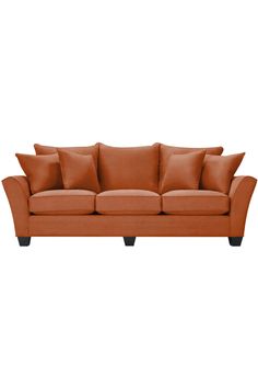 an orange couch with several pillows on it's back and one in the middle