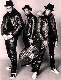 three men standing next to each other with a boombox in front of their backs