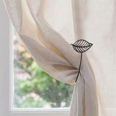 a white curtain with a black leaf on it