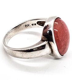 Badavichi Rhodonite pink gemstone signed vintage sterling silver ring. Good vintage condition with little to no signs of normal vintage wear. Beautiful pink Rhodonite color. Bezel set stone in solid sterling silver setting. Stamped Badavichi HK 925 on the inside of the band. Acid tests positive for sterling silver. Ring measures size 10. Pink Moonstone Sterling Silver Ring For Anniversary, Pink Cabochon Ruby Ring, Pink Round Cabochon Ruby Ring, Vintage Sterling Silver Opal Ring, Vintage Round Sterling Silver Opal Ring, Vintage Hallmarked Rings With Round Stone, Vintage Hallmarked Ring With Round Stone, Vintage Sterling Silver Moonstone Ring For Formal Occasions, Vintage Cabochon Ring For Promise