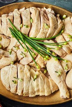 sliced chicken with green onions and scallions in a brown bowl on a table