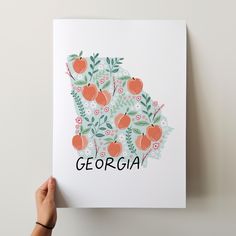 a hand holding up a card with the word georgia written in black and orange on it