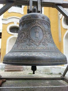 a large metal bell sitting on top of a sidewalk