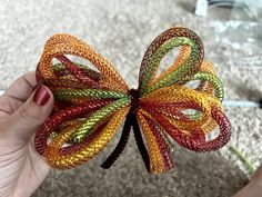 a person is holding a colorful bow made out of string