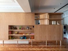 an empty room with wooden shelves on the wall and wood flooring in front of it