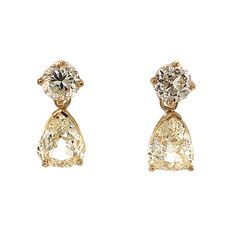 These exquisite modern drop earrings feature 4.51 total carats of diamonds in 18 karat yellow gold. Two (2) pear cut fancy yellow diamonds dangle softly from the diamond studs. The fancy yellow diamonds have a vibrant golden hue and are cut for maximum brilliance. The pear cut diamonds are prong set with two protective prongs at each point of the pear shape. Two (2) old European cut faint yellow diamonds decorate the 18K stud backings. Glamourous and expertly designed, these fancy yellow diamond Elegant Luxury Yellow Gold Cluster Earrings, Luxury Yellow Gold Sterling Silver Chandelier Earrings, Luxury Brilliant Cut Yellow Gold Cluster Earrings, Luxury Yellow Gold Pierced Cluster Earrings, Pear Cut Diamond Earrings, Yellow Diamonds, Fancy Yellow Diamond, Pear Cut Diamond, Shop Engagement Rings