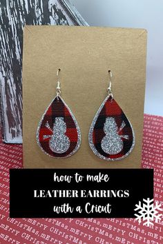 a pair of red and black tear earrings with snowflakes on them