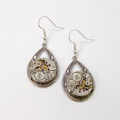 Small Helen Drop Round watch movement dangle earrings . These unique watch dangles are sure to be a great conversation starter! Wear them everyday or on special occasions, people will be intrigued by the genuine vintage watch parts in the design! They will make a splendid gift for any lady who loves all things Victorian. The watch pieces come from authentic salvaged antique watch parts. The parts are soldered into the design, which also incorporates boho style oval drop on hypoallergenic stainle Moon Goddess Necklace, Small Dangle Earrings, Steampunk Earrings, Antique Watch, Round Watch, Vintage Timepiece, Goddess Necklace, Antique Watches, Watch Parts