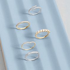 three different types of rings sitting on top of a blue surface with one ring in the middle