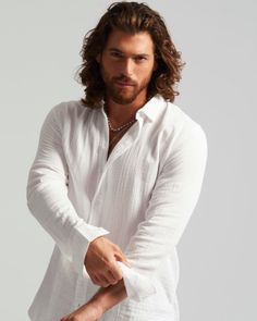 a man with long hair wearing a white shirt