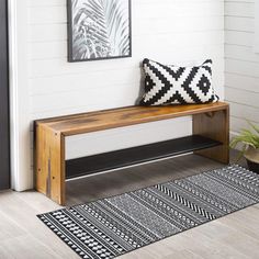 a black and white rug sitting next to a wooden bench on top of a hard wood floor