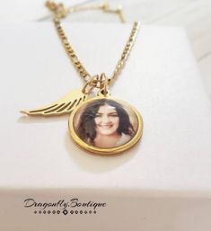 14k Gold Photo Necklace with Angel Wing. Pendant is 20mm in Size. Chain 3mm thick. Gold Plated on Stainless Steel. High Quality. Does Not Tarnish Personalized Gold Jewelry For Memorial, Gold Round Pendant Charm Necklace For Memorial, Personalized 14k Gold Jewelry For Memorial, Personalized 14k Gold Memorial Jewelry, Customizable Rose Gold Jewelry For Memorial, Gold Nickel-free Necklace For Memorial, Customizable Rose Gold Memorial Jewelry, Personalized Gold Charm Necklaces For Memorial, Personalized Gold Charm Necklace For Memorial