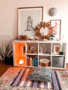 a living room area with a rug, bookshelf and pictures on the wall