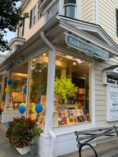 a book store on the side of a building with balloons and flowers in front of it