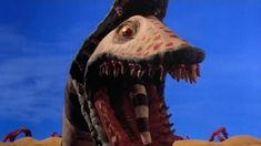 an animated creature with large teeth and huge mouth standing in the middle of a desert