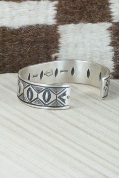 This sterling silver bracelet was made by Navajo silversmith Calvin Martinez. The inside is signed C MTZ, Navajo and stamped sterling.Size: 5 3/8" (will fit up to a 6 3/8" wrist)Gap: 1"Width: 5/8"Free shipping on all orders! We ship with USPS and always include tracking. All orders ship within a day of payment.Returns are accepted up to 30 days after you receive your order. Just send us a message. Our shop offers cash back or store credit. The item must be returned in new condition. Southwestern Silver Cuff Bracelet With Inlay, Southwestern Style Etched Sterling Silver Bracelet, Sterling Silver Southwestern Bracelet, Artisan Sterling Silver Bracelet With Inlay, Southwestern Sterling Silver Stamped Bangle Bracelet, Southwestern Style Stamped Sterling Silver Bangle Bracelet, Southwestern Style Stamped Sterling Silver Bangle, Southwestern Sterling Silver Bracelet, Sterling Silver Bracelet