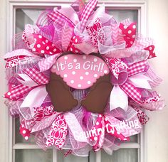 a pink and white wreath with it's a girl on it