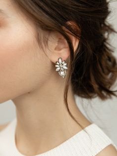 a close up of a person wearing some kind of earring with flowers on it