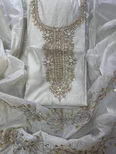 a white dress with gold beading on it