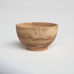 a wooden bowl sitting on top of a white table