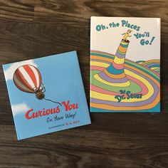 two children's books sitting on top of a wooden table next to each other