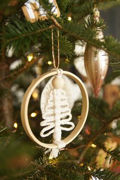 an ornament hanging from a christmas tree in the shape of a fern leaf