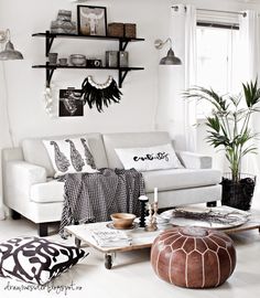 a living room filled with white furniture and lots of shelves on the wall next to a window