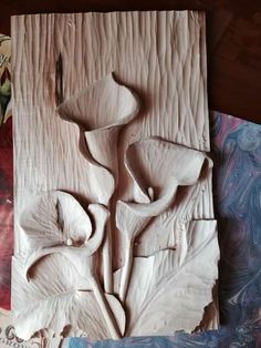 a close up of a flower carving on a piece of wood