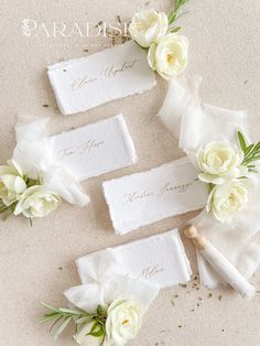 wedding place cards with white flowers and greenery