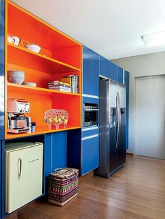 an orange and blue kitchen with wooden floors