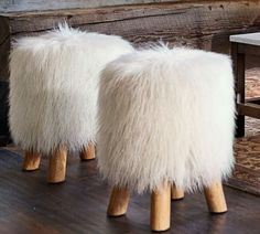 two sheepskin stools sitting on top of a wooden floor