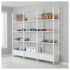 a white shelf filled with lots of clothes and bags on top of it's shelves