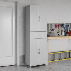 a white cabinet next to a workbench with tools on it