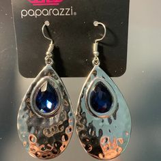 Paparazzi Tranquil Trove Blue Earrings With Fish Hook Fittings A Shiny Silver Teardrop Is Hammered In Texture, Creating A Radiant Display As The Light Bounces Off Each Beveled Surface. A Faceted Blue Teardrop Gem Is Pressed Into The Top Of The Silver Frame In An Enchanting Finish. Blue Drop Earrings With Fish Hook, Blue Fish Hook Earrings For Gift, Elegant Metal Jewelry With Fish Hook, Gift Blue Fish Hook Earrings, Elegant Metal Jewelry With Hook Closure, Teardrop Blue Jewelry For Party, Blue Teardrop Jewelry For Party, Blue Metal Teardrop Earrings Gift, Blue Nickel-free Teardrop Earrings For Party