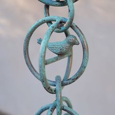 a close up of a metal chain with birds on it's links and the sky in the background