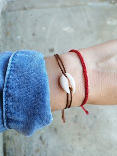 Cowrie shell on cream/black/brown/gray string - a must have beachy bracelet, goes easy with everything:) - Minimalist string bracelet with adjustable sliding closure. - Easy to fit to the wrist due to adjustable size closure. - Extra parts of the closure each measures about 2 inches or shorter on request. - A string bracelet is a symbolic gift to be offered to anyone, as a talisman to protect from negativity. - The string is waxed cotton. - Suitable as an anklet, large size available at checkout Adjustable String Bracelet, Cowrie Shell Bracelet, Beachy Bracelets, Black Tourmaline Bracelet, Red Rope, Tourmaline Bracelet, Shell Bracelet, Birthstone Gifts, Amethyst Bracelet