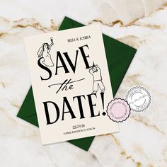 save the date card on top of a green envelope next to a pink and white flower