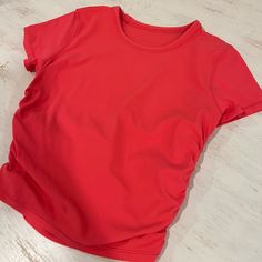 a red shirt sitting on top of a white table