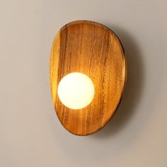 a wooden object with a light on top of it and a gray wall in the background