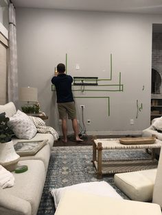 a man is painting the walls in his living room