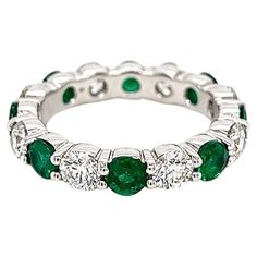 3.36 Total Carat Green Emerald and Diamond Ladies Ring Highly Polished 1.86 Carat Diamond Eternity Band with Green Emerald Gemstone Carat Weight of 1.50 CT. Specifications: -Metal Type: 18K White Gold -1.50 Carat Round Cut Columbian Green Emerald -1.86 Carat Round Natural Diamonds, G-H Color, VS2-SI Clarity -Size 6.25 Proudly made in New York City. Emerald Diamond Ring With Diamond Accents, Luxury Gia Certified Round Eternity Band, White Emerald Round Cut Ring, White Emerald Ring With Round Cut, Classic Gemstone Eternity Band, Luxury Round Gemstone Eternity Band, Classic Gemstone Eternity Band For Formal Occasions, Emerald Ring With Brilliant Cut Diamond White, Formal Gia Certified Eternity Band Fine Jewelry