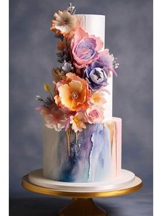 a multi - tiered cake with colorful flowers on top