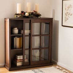 a book case with candles on top of it