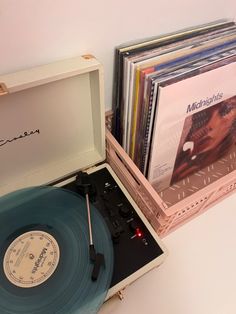 an old record player sitting on top of a table next to cd's and cds