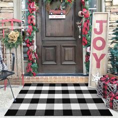 an orange and white checkered rug in front of a door with christmas decorations on it