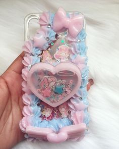 a hand holding a phone case with an image of a heart in the center and flowers on it